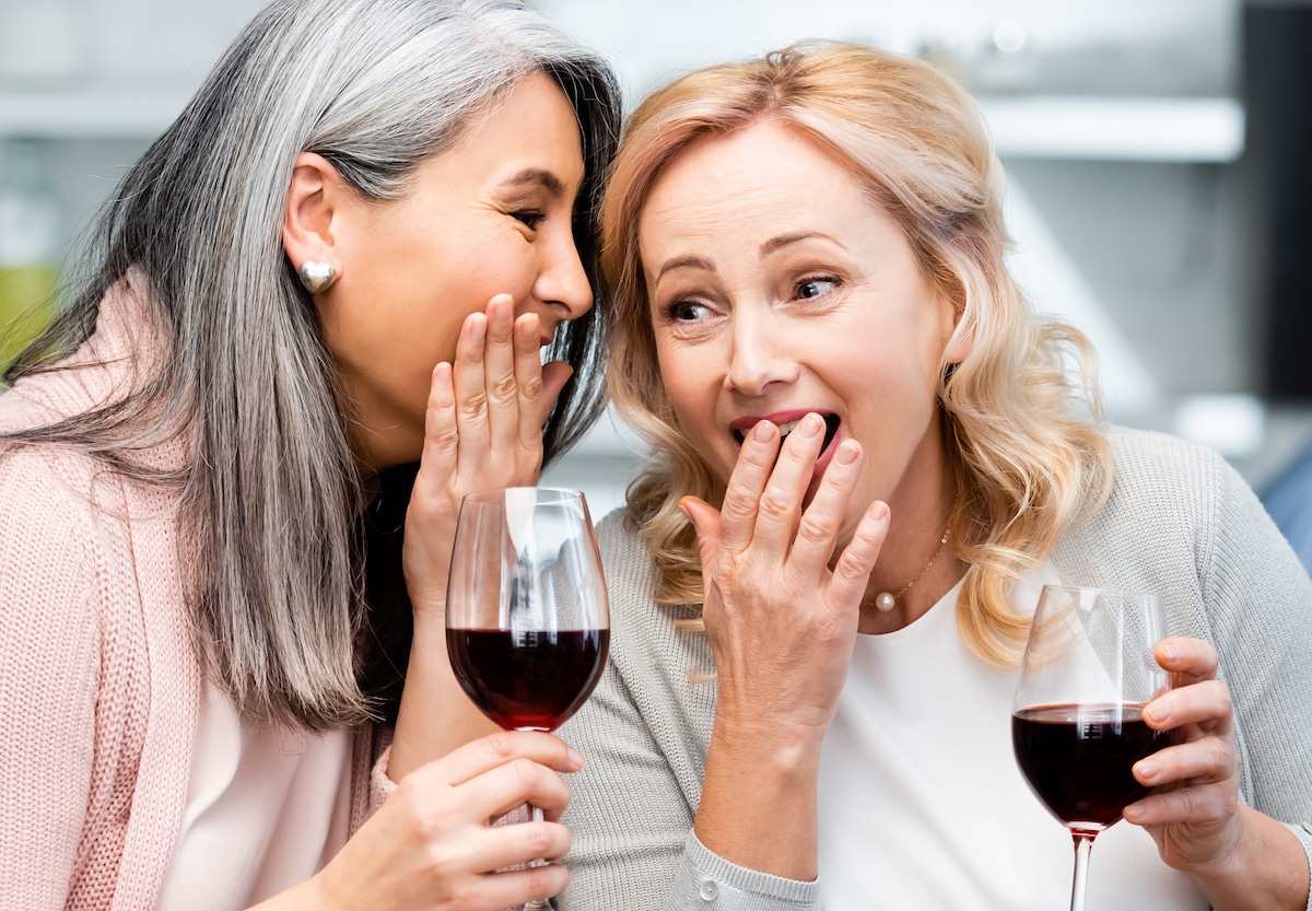 women laughing drinking wine