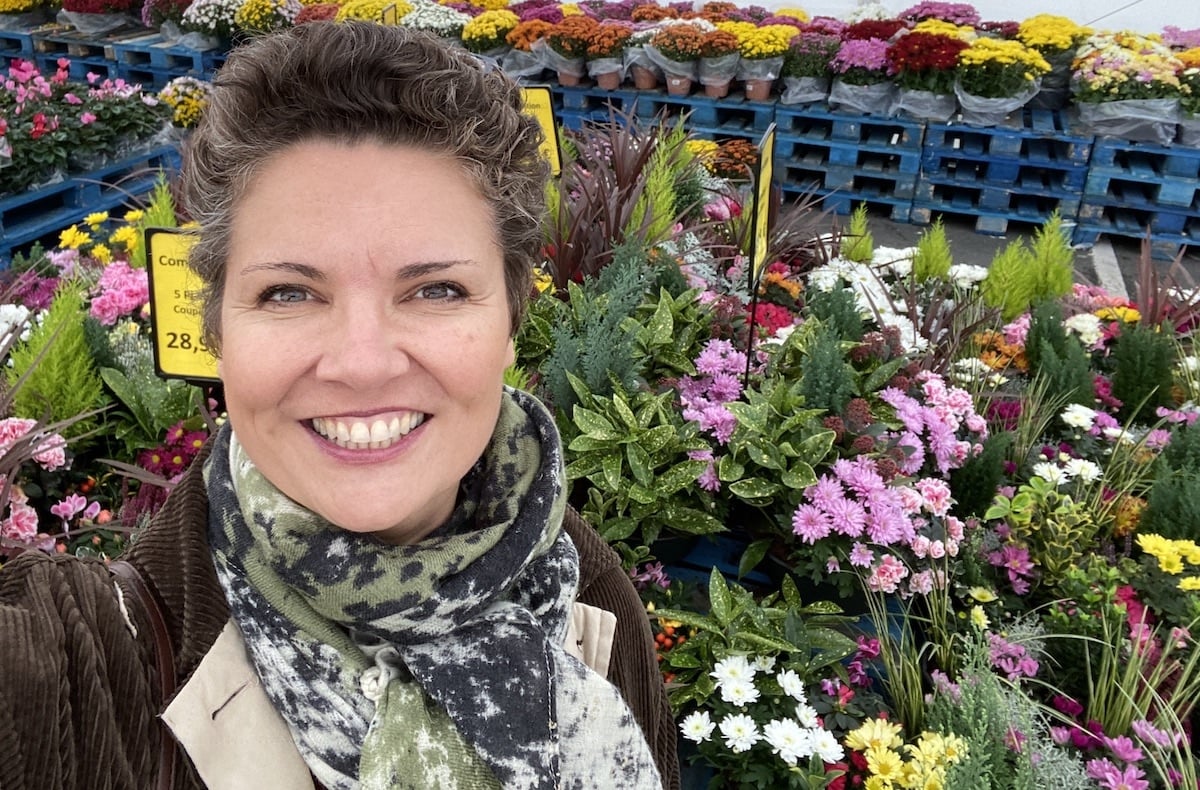 Camille in front of flowers for la Toussaint in France