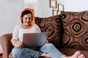 latino senior woman studies french on her computer