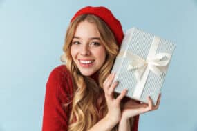 young woman with beret holding gift