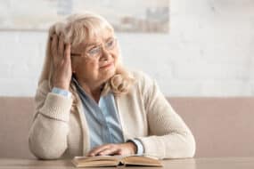 Senior woman tries to learn French with book and is frustrated